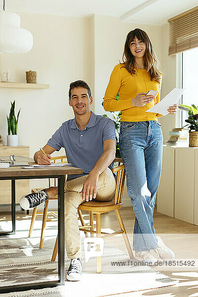 Smiling freelancing couple at home office