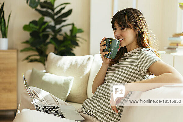 Smiling woman having coffee at home