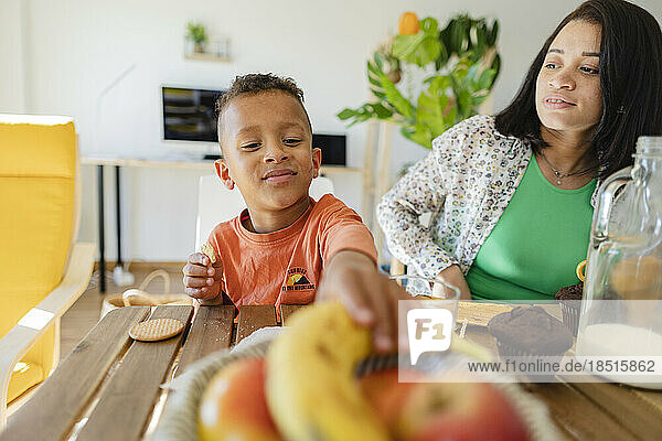 Boy having breakfast with mother at dining table