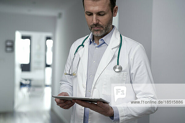 Mature doctor using tablet PC in clinic