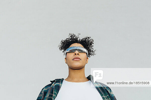 Junge Frau mit Smart-Brille vor der Wand