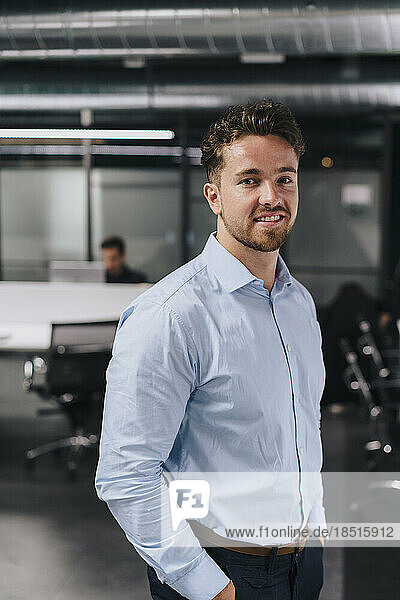 Smiling young businessman standing in office