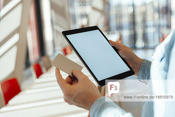Businessman with credit card and tablet PC