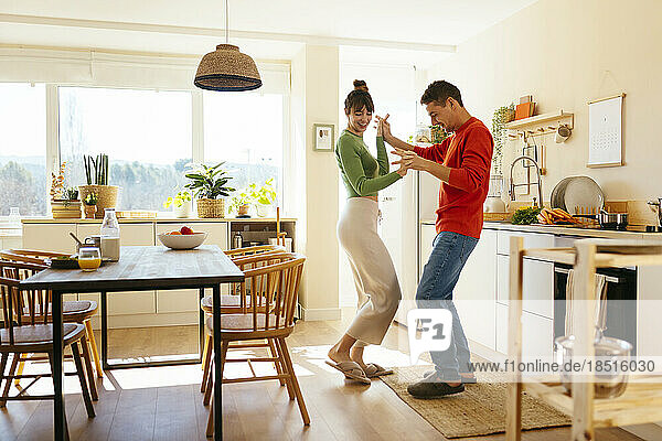 Happy couple dancing in kitchen