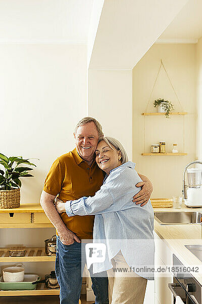 Zärtliches Seniorenpaar umarmt sich in der Küche