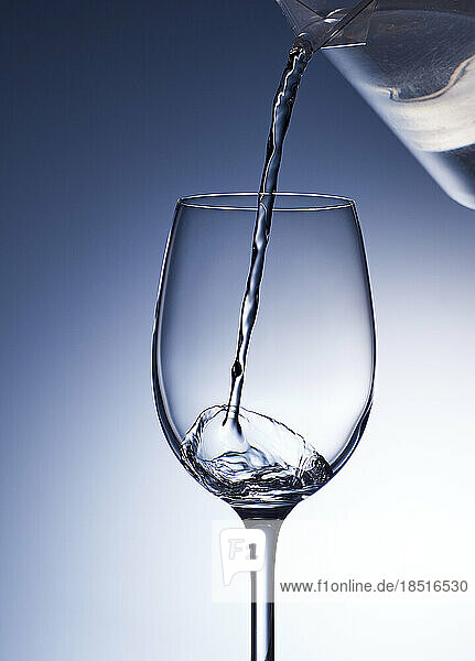 Studio shot of clear water pouring into wineglass