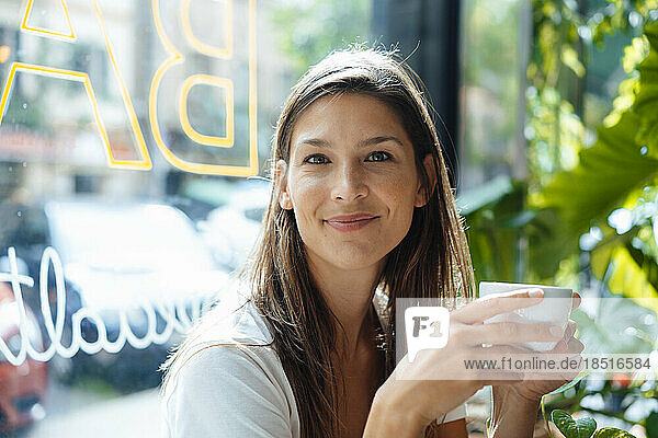 Smiling woman with coffee cup in cafe