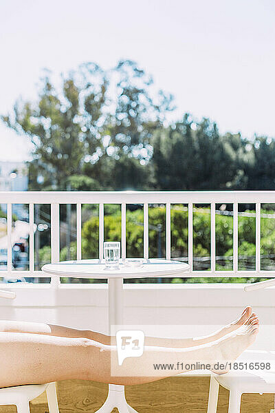 Frau entspannt sich an einem sonnigen Tag auf dem Balkon