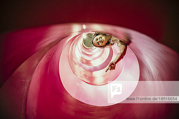 Smiling woman gesturing inside spiral structure
