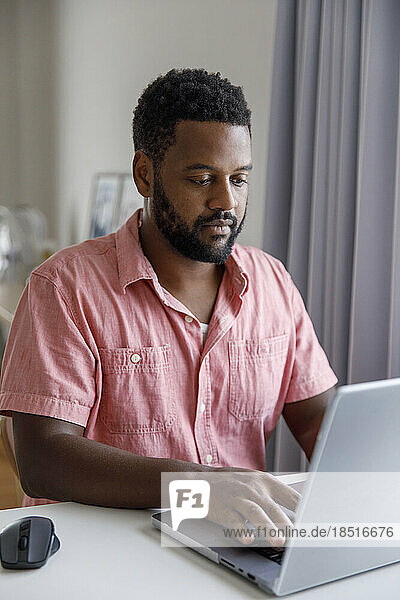 Freelancer typing on laptop at home