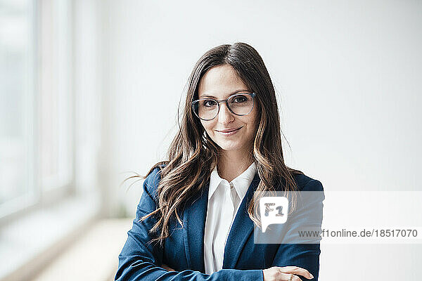 Lächelnde Geschäftsfrau mit Brille steht im Heimbüro
