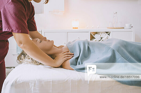 Therapist giving body massage to customer in salon