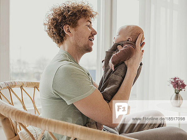 Man playing with son at home