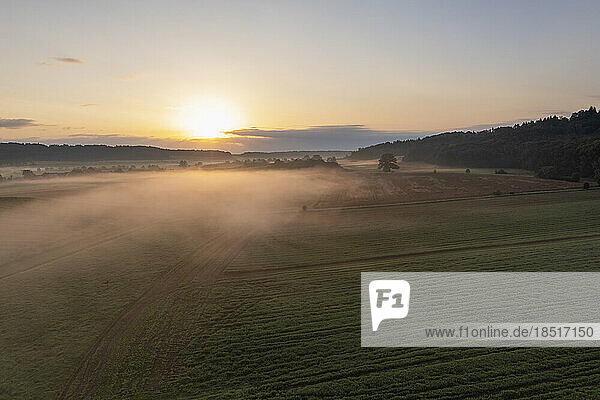 Germany  Bavaria  Aerial view of agricultural field at foggy sunrise