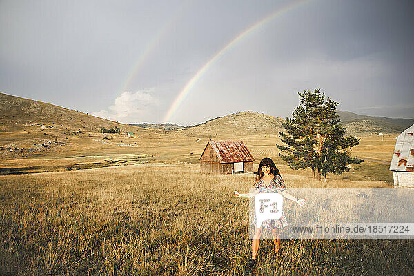 Happy young woman walking in meadow