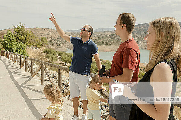 Man gesturing and talking with family at vacations