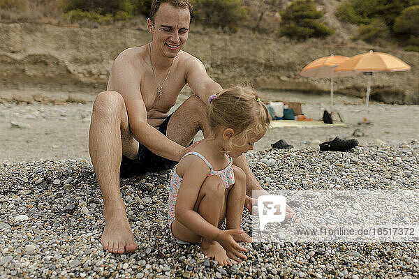 Father with daughter playing at beach
