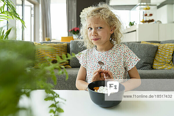 Blondes Mädchen weigert sich zu Hause  Essen in einer Schüssel zu essen