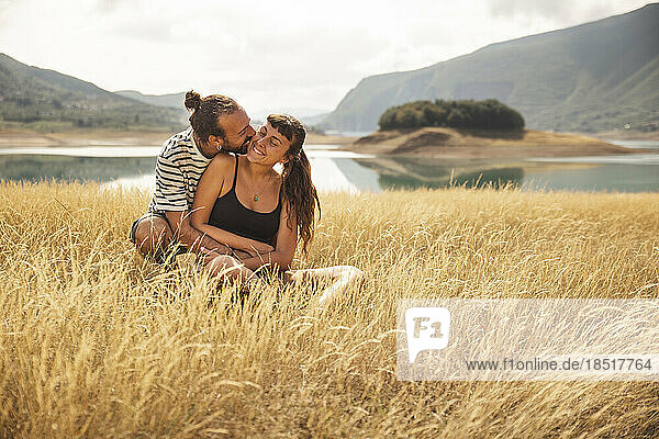 Happy man embracing woman in front of Rama Lake