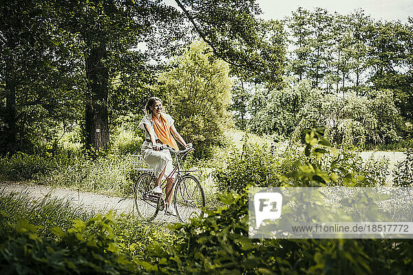 Frau fährt Fahrrad inmitten von Bäumen