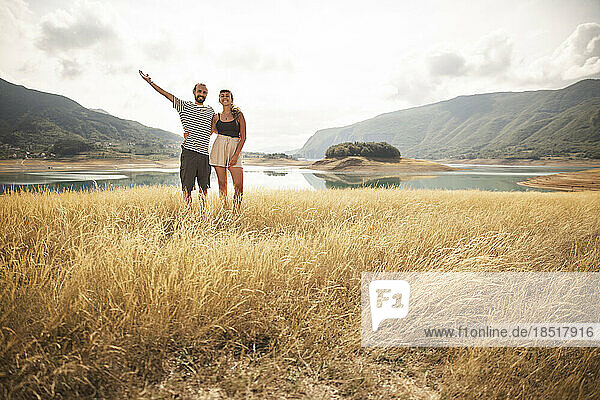 Carefree couple standing in front of lake