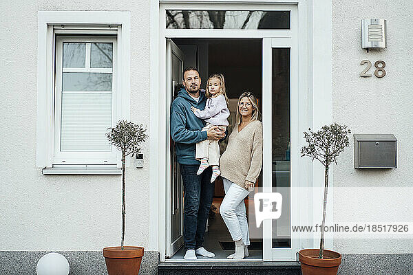 Happy family standing at front door