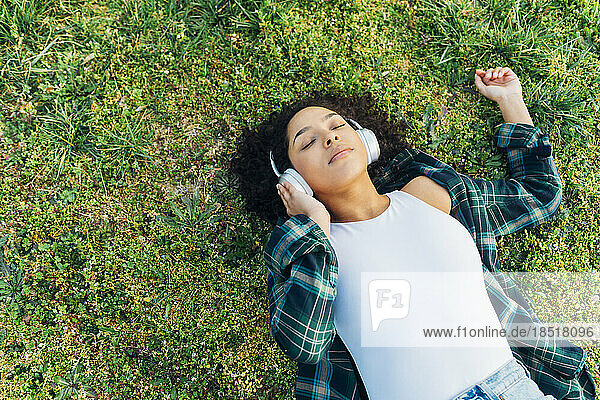 Young woman with eyes closed relaxing and listening to music