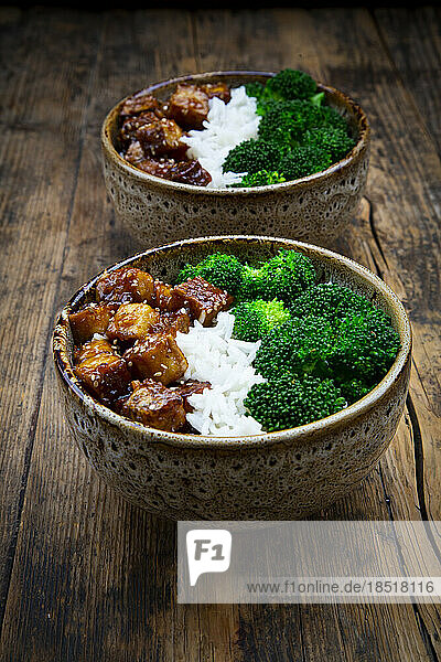 Two bowls of coconut rice with tofu  broccoli and sesame seeds