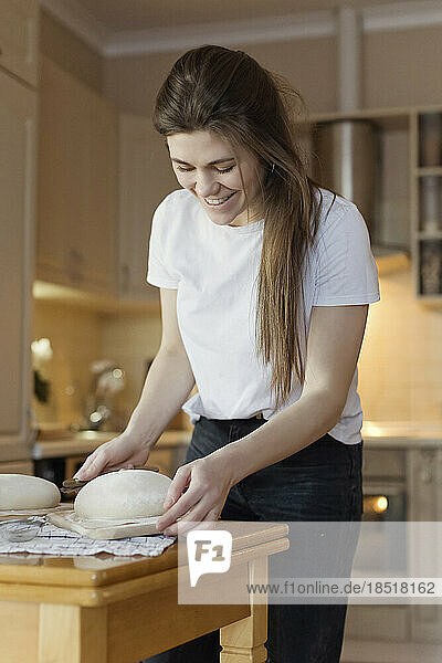 Happy woman baking bread at home