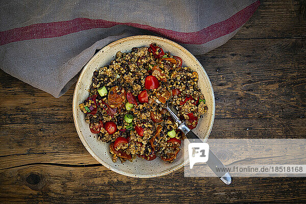 Bowl of Beluga lentils with bulgur  tomatoes  peppers  eggplant and scallion