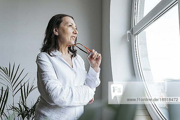 Thoughtful businesswoman standing near window