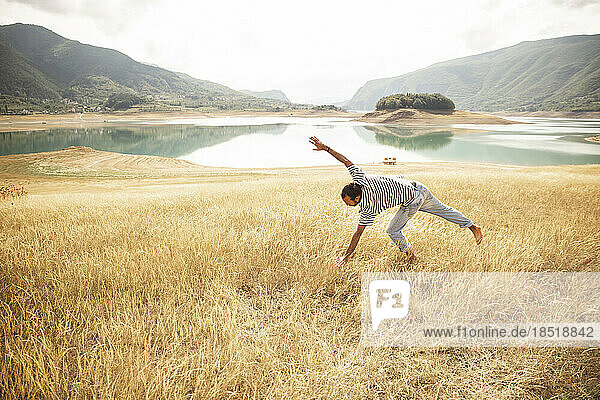 Man doing cartwheel in front of lake