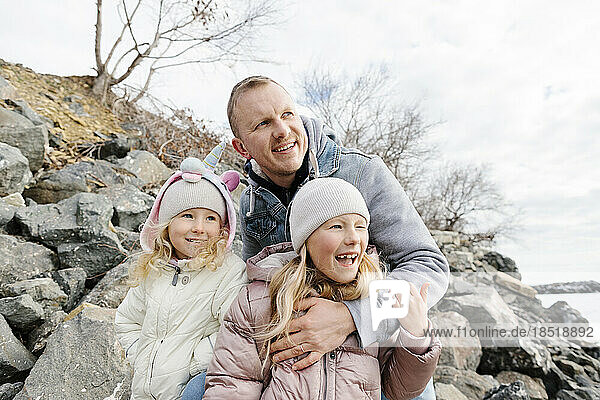 Happy father enjoying with daughters by rocks