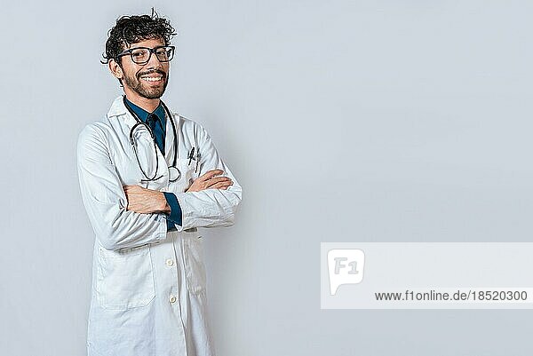 Smiling doctor with crossed arms on isolated background. Latin doctor with crossed arms on isolated background  Portrait of young doctor with arms crossed