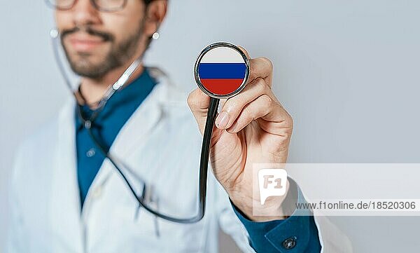 Russland Flagge auf Stethoskop. Arzt hält Stethoskop mit Flagge von Russland. Arzt zeigt Stethoskop mit Flagge der Russischen Föderation