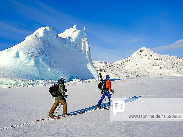 Skibergsteiger vor Eisberg im gefrorenen Kong Oscar Fjord  Tasiilaq  Insel Ammassalik  Kommuneqarfik Sermersooq  Ostgrönland  Grönland  Nordamerika