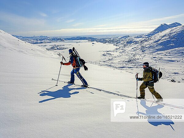 Ski mountaineer on ski tour  frozen Kong Oskar Fjord behind  Tasiilaq Ammassalik Island  Kommuneqarfik Sermersooq  East Greenland  Greenland  North America