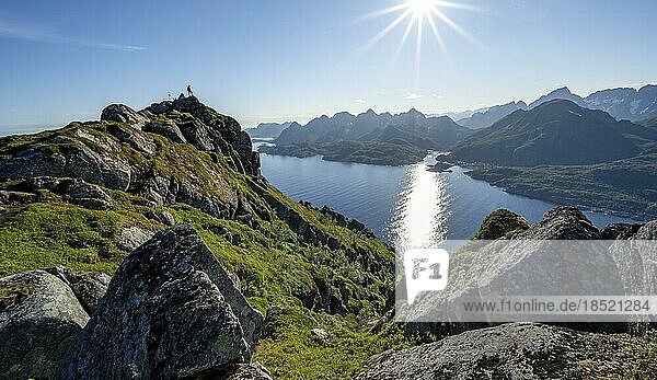 Wanderer am Gipfel des Dronningsvarden oder Stortinden  Ausblick auf Fjord Raftsund und Berge  Sonnenstern  Vesterålen  Norwegen  Europa