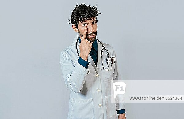Male doctor making gesture of watching you. Doctor making gesture of watching you. Concept of doctor with surveillance gesture