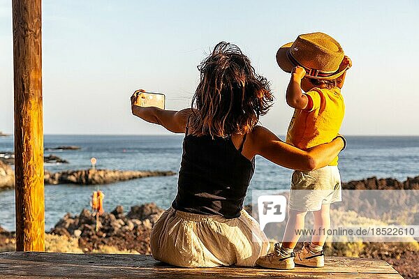 Mutter und Sohn im Urlaub beim Fotografieren am Strand von Tacoron auf El Hierro  Kanarische Inseln. Spaß haben  Junge mit Hut