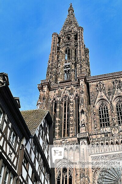 Turm des berühmten Straßburger Münsters in Frankreich in romanischem und gotischem Baustil mit traditionellem Fachwerkhaus im Vordergrund