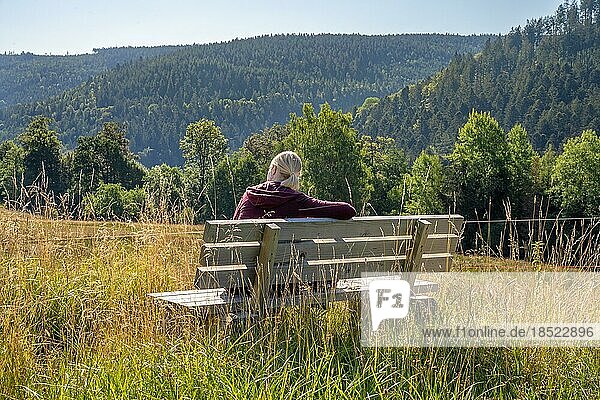 Wanderer Frau sitzt auf Bank und schaut auf die Wälder  Sprollenhäuser Hut  Bad Wildbad  Schwarzwald  Deutschland  Europa