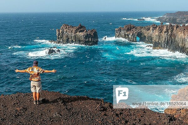 El Hierro Island. Canary Islands  man tourist at the Arco de la Tosca looking at the monument on the coast
