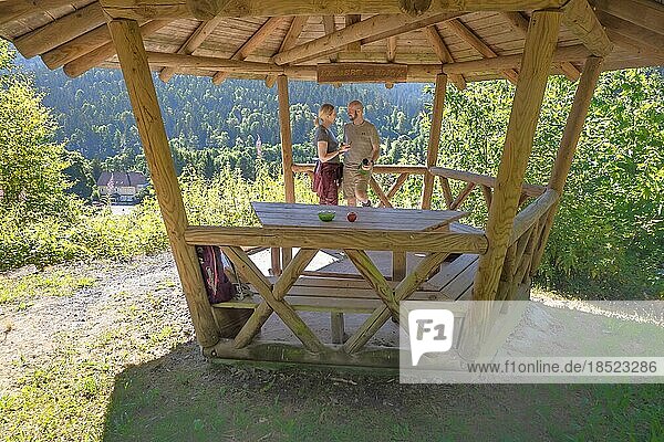 Wanderpärchen macht Pause in Holzpavillion auf dem Wanderweg Sprollenhäuser Hut  Bad Wildbad  Schwarzwald  Deutschland  Europa