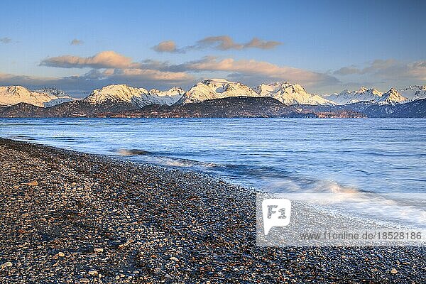 Evening atmosphere at Homer Spit with view over the stone beach and Kachemak Bay to the Kenai Mountains in the warm evening light in the background  Kenai Peninsula  Alaska  USA  North America