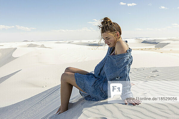 United States  New Mexico  White Sands National Park  Teenage girl sitting on sand