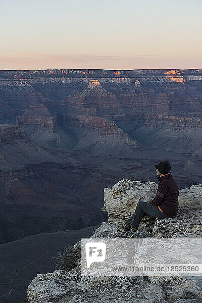 United States  Arizona  Grand Canyon National Park  South Rim  Senior female hiker sitting at edge of Grand Canyon and looking at view 