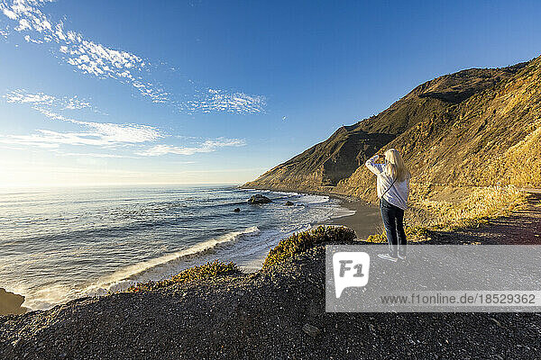 United States  California  Big Sur  Senior blonde woman looking at Pacific Ocean