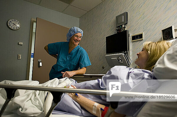 Patient und medizinisches Personal unterhalten sich in einem Aufwachraum nach einer Operation; Lincoln  Nebraska  Vereinigte Staaten von Amerika