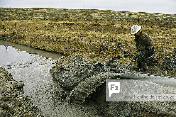 Worker samples water from a well at a coalbed methane drill site; Buffalo  Wyoming  United States of America